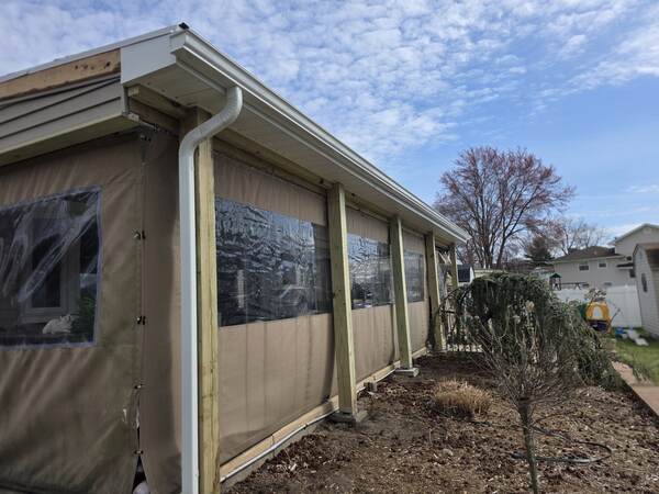 New white seamless aluminum gutter system installed on a South Jersey home, downspout and proper pitch visible
