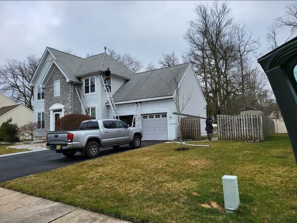 Old gutter tear-off and replacement with dumpster on site, gutter installer at the eave